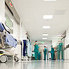 Krankenhausflur im OP-Trakt: OP-Beschäftigte kommen aus OP-Sälen heraus bzw. gehen in diese hinein.