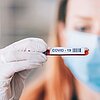 Medizinische Fachangestellte hält Röhrchen mit Blut in der Hand, das auf das Coronavirus untersucht werden soll.