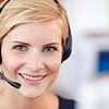 Lächelnde Beschäftigte eines Service Call Centers mit Headset